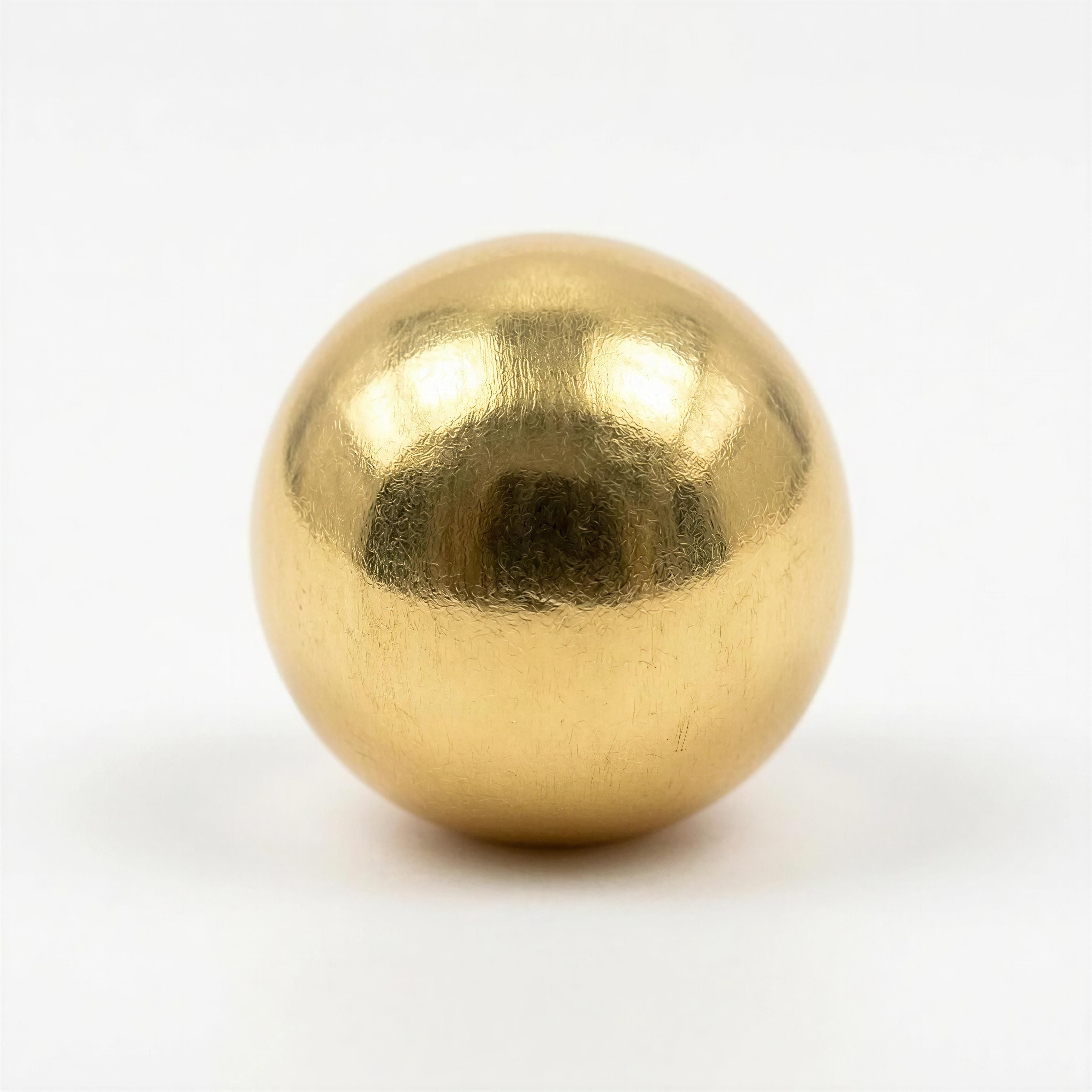 Close-up of a polished gold bead with subtle textured surface, showcasing the artisanal elegance of The Solea Collection - Lux Aeterna.