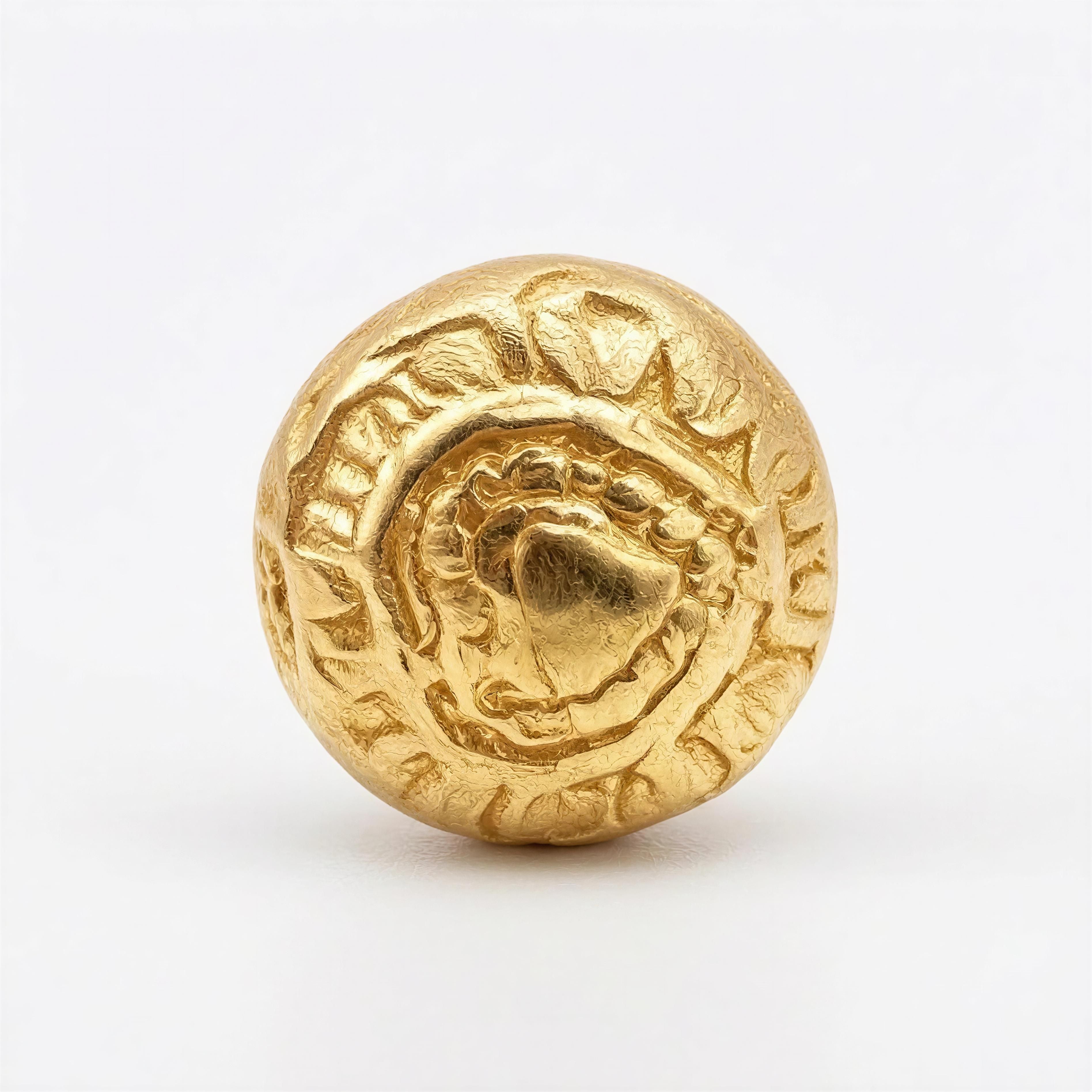 Close-up of a textured gold bead with intricate heart and leaf patterns, part of the Limited Edition - Aurea Luminis collection by Atelier X, showcasing handcrafted luxury jewelry.