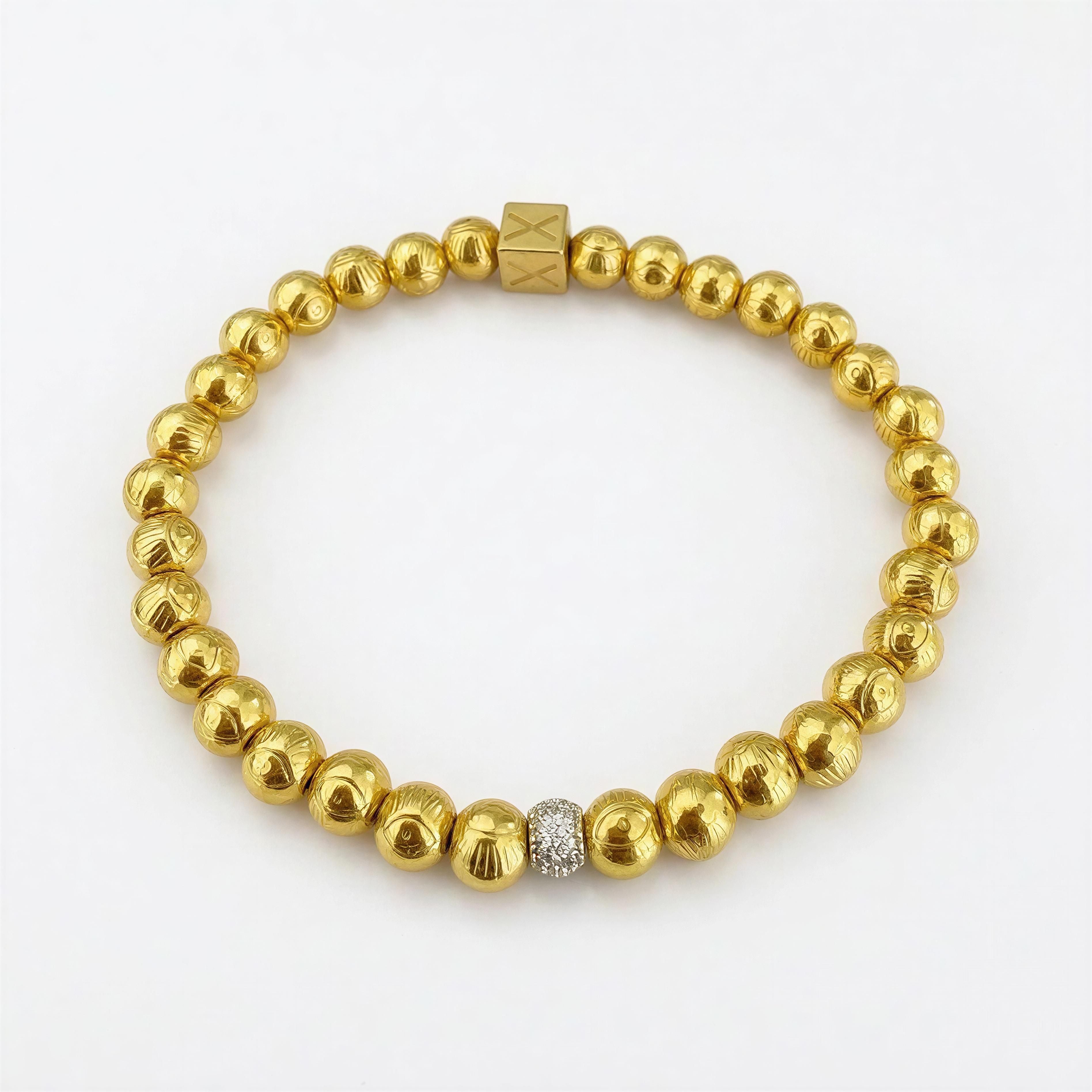 XX Elégance- Golden Vision bracelet featuring polished gold beads with textured details and a single sparkling bead, embodying handcrafted luxury jewelry by Atelier X.
