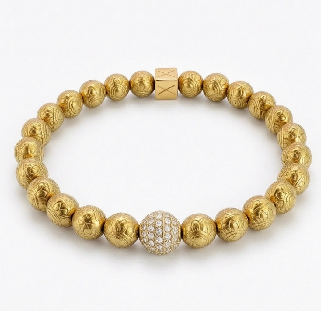 Limited Edition - Orbis Aurea Imperium bracelet featuring handcrafted gold beads with intricate designs and a central bead encrusted with sparkling crystals.
