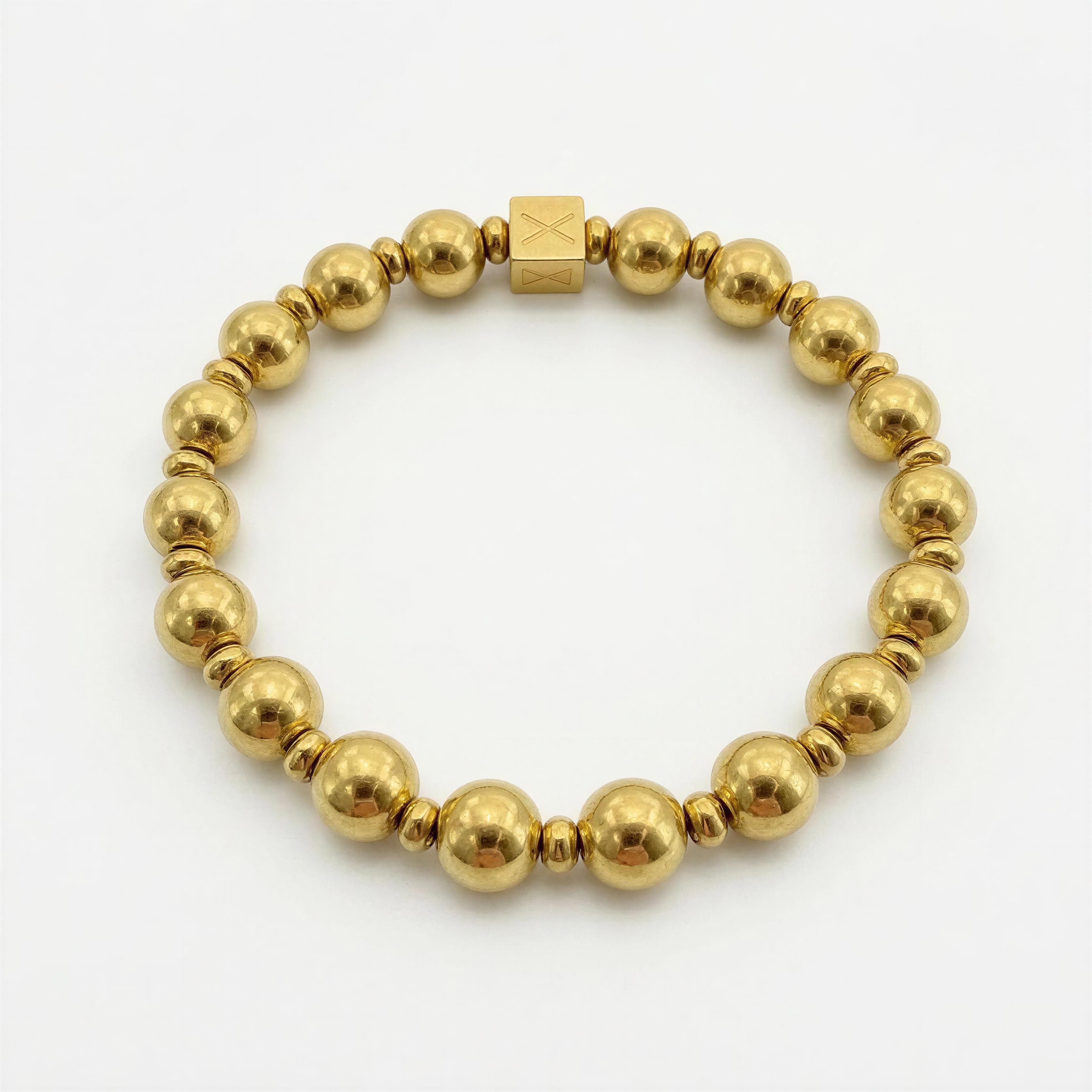 Elegant gold-tone beaded bracelet featuring round and small spacer beads with a signature cube bead, showcasing "The Essential Collection - 8mm & 4mm" luxury design.